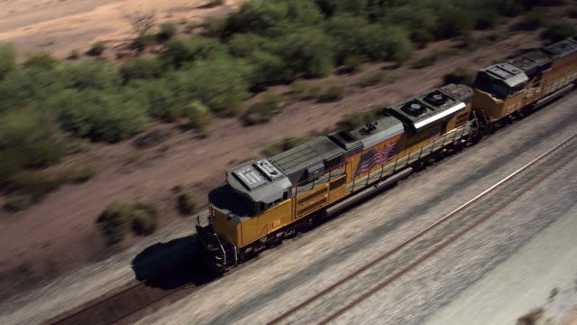 AERIAL: Long container freight train transporting goods across the country