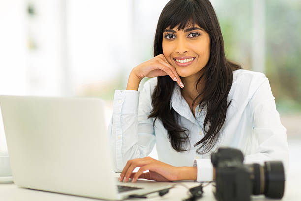 istock female photographer sitting in office 528195543
