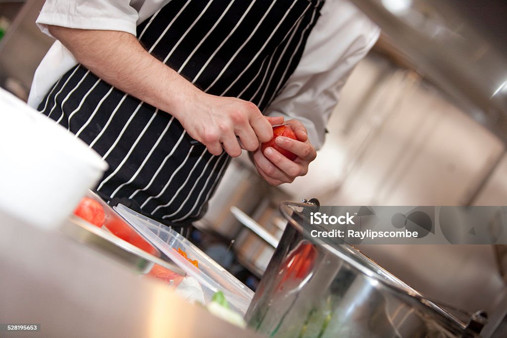 Sous chef preparing Tomatoes Sous chef peeling the skins of tomatoes in a commercial kitchen Adult Stock Photo