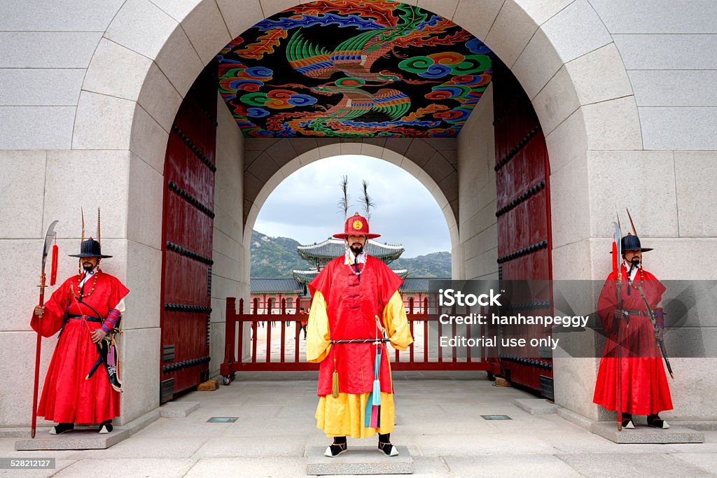 Guards at Gyeongbokgung Palace Seoul, Republic of Korea - May 01, 2013: Three royal guards in red uniforms standing in front of the main gate to Gyeongbokgung Palace. Adult Stock Photo