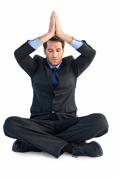 istock Calm businessman sitting in lotus pose with hands together 528212319