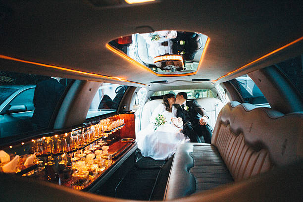 recém-casados: noiva e noivo, sentado em uma limusine gigante - limousine - fotografias e filmes do acervo
