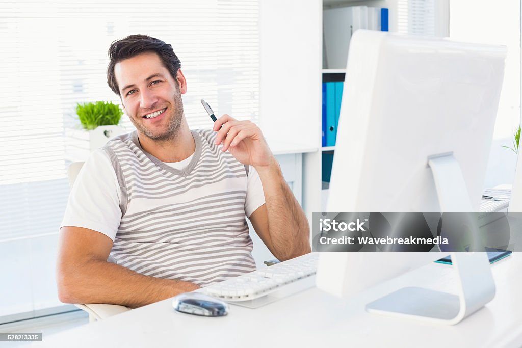 Smiling man with computer in a bright office Relaxed smiling man with computer in a bright office 30-34 Years Stock Photo