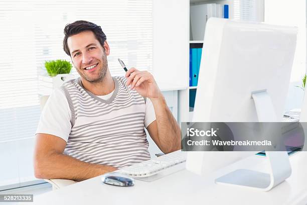 Smiling Man With Computer In A Bright Office Stock Photo - Download Image Now - 30-34 Years, 30-39 Years, Adult