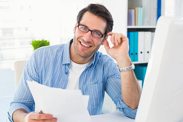 istock Smiling photo editor at work holding contact sheet 528213545