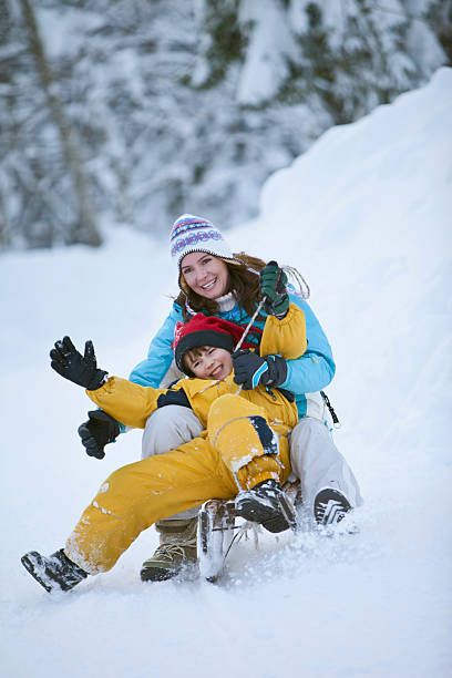 istock Germany, Bavaria, Mother and son sledding downhill, laughing 528213701