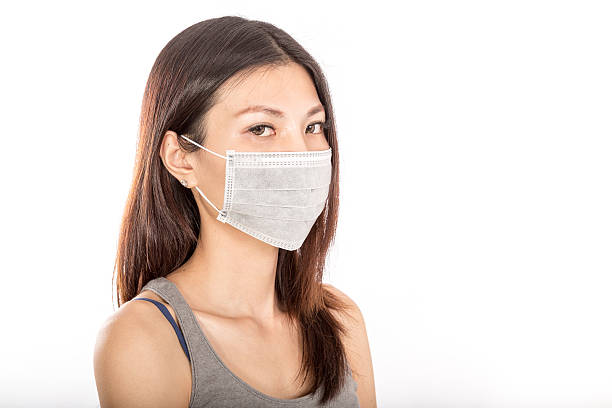 istock Asian woman wearing surgical mask 528218175
