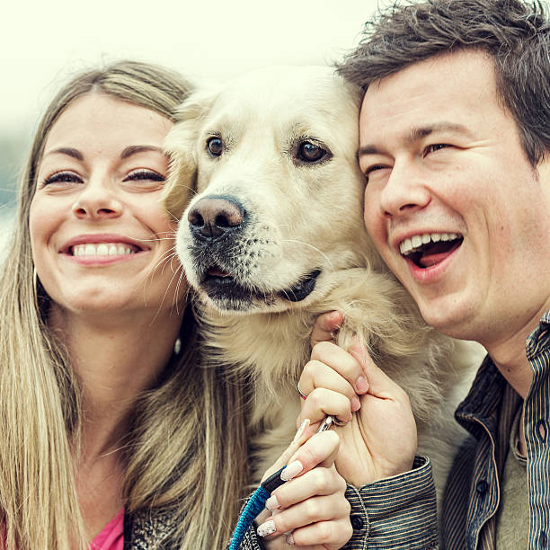 istock Smiling young man and woman hugging a dog 528218623