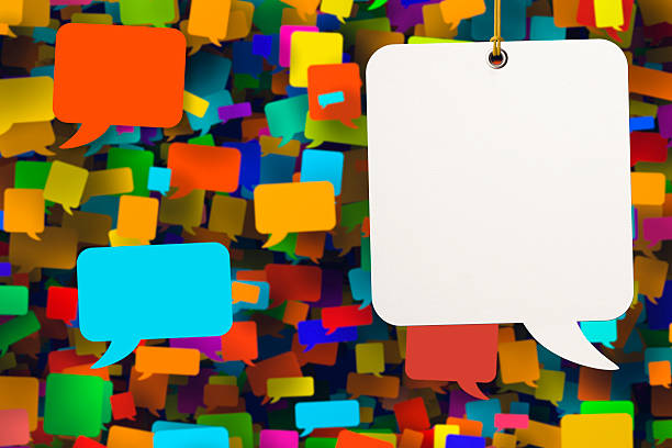 istock Blank white speech bubble amongst background of coloured speech bubbles 528219627