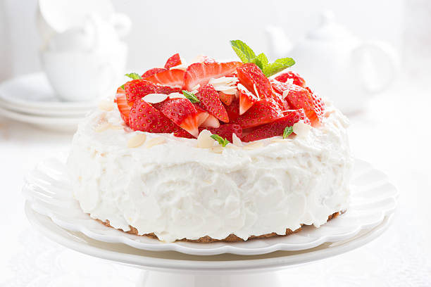 istock cake with whipped cream and strawberries on a stand 528239747