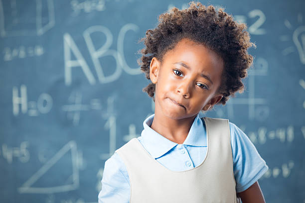 istock Confused private elementary school student standing at front of classroom 528243567