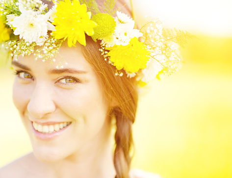 A gorgeous young woman with a flower wreath on her head..