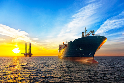 Tanker ship and Oil Platform on offshore area at sunset.