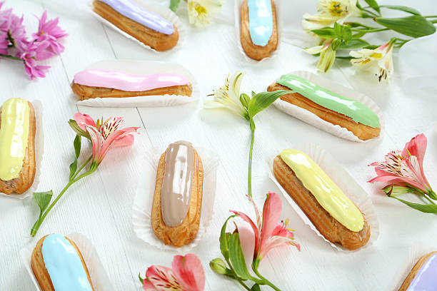 istock Eclairs with glaze on a white wooden table 528282774