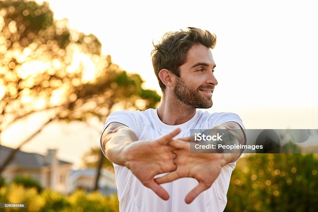 Focused on fitness Shot of a man stretching before a run Men Stock Photo