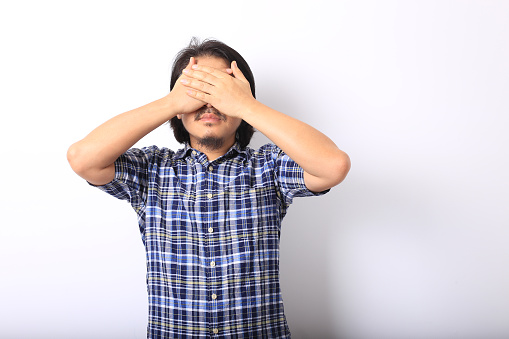 The asian man in the blue plaid shirt with closed eyes.