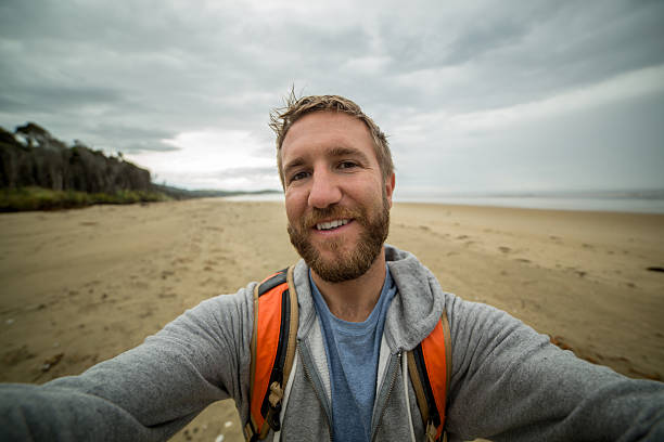 istock Cheerful young man takes a selfie portrait on a beach 528285880