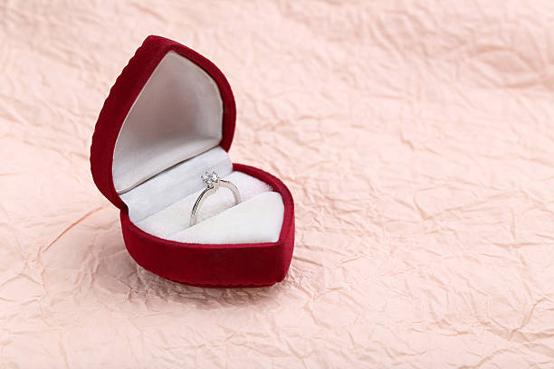 istock Diamond ring in box on a pink paper background 528288842