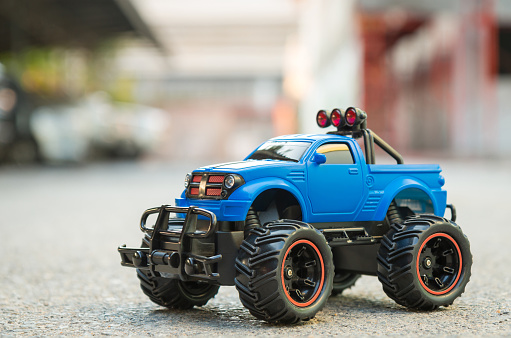 Blue RC truck car (Radio-controlled car) on the asphalt ground. Off road car. This toy have some dust from children playing.