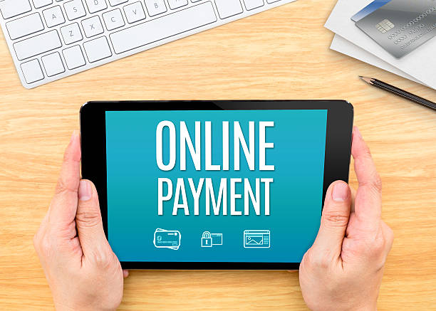 istock Hand holding tablet with Online payment word on wood table 528291306
