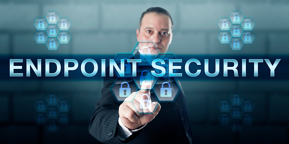 Manager is pushing ENDPOINT SECURITY on a virtual touch screen interface. Information technology and security concept for software and technology protecting corporate computing networks.