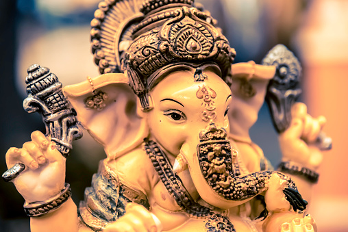 Yellow rasin Ganesh Elephant god statue closeup focused on face vintage tone