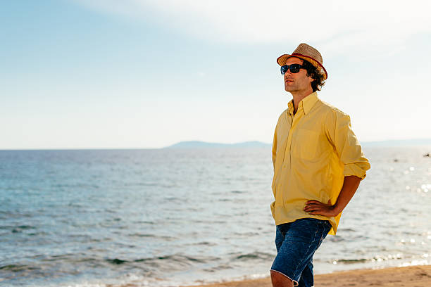 istock Handsome tourist at sea shore posing and looking at sunset 528293884