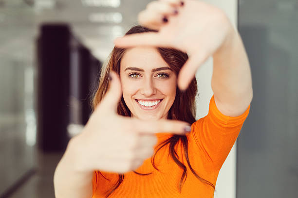 Young woman framing with hands Close up of smiling girl making frame with hands hand cropping photos stock pictures, royalty-free photos & images
