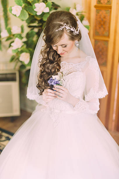 istock Beautiful bride with long curly hair and veil looking at 528299536
