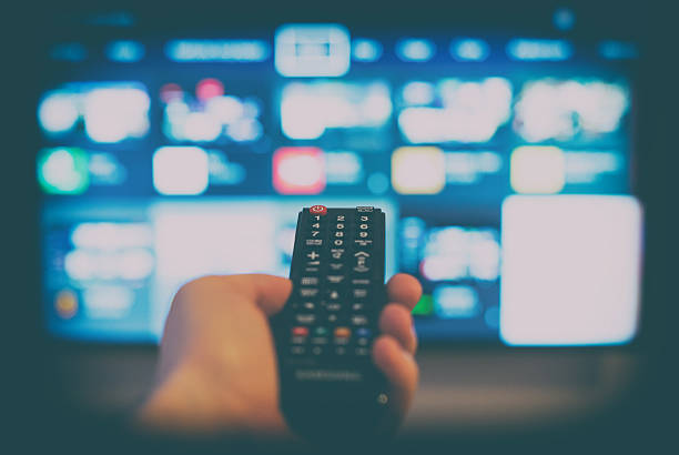 istock Male hand holding TV remote control. 528301238