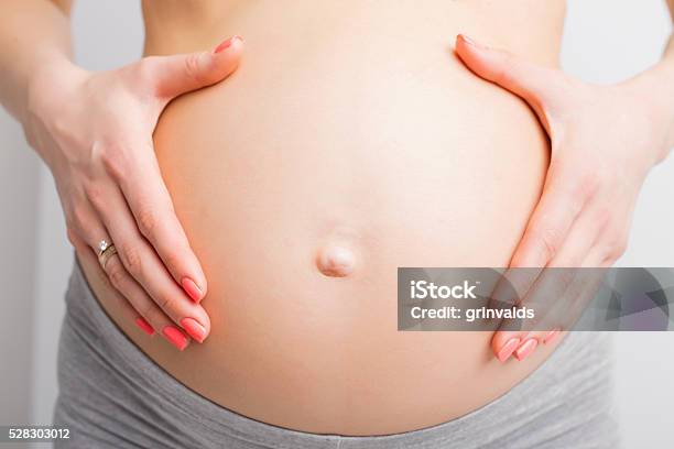 Pregnant Woman Holding Baby Bump Stock Photo - Download Image Now - Pregnant, Colliding, Childbirth