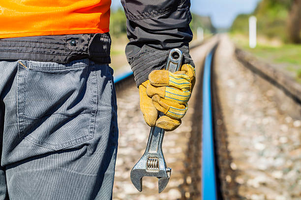 istock Railroad worker with adjustable wrench on railway in spring 528305094