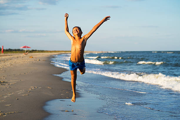 istock Happy boy running on the sea beach at summer 528306348