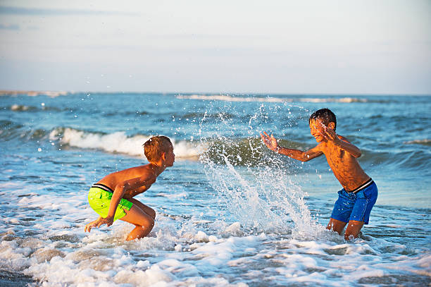istock Two boys playing at the beach with water. Big splashes 528306592