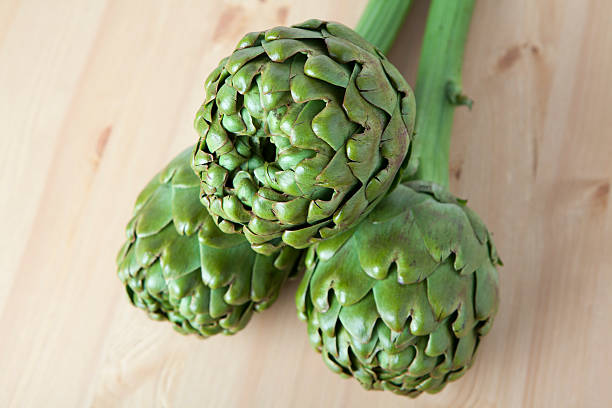 istock artichokes on wooden surface 528307804