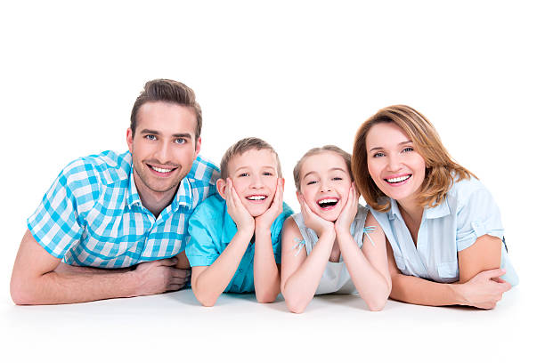 Caucasian happy smiling young family with two children Caucasian happy smiling young family with two children lying down on the  floor woman lying on the floor isolated stock pictures, royalty-free photos & images