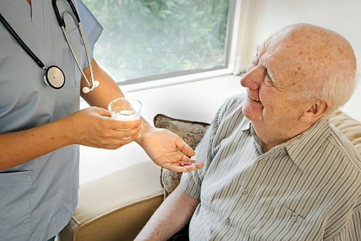 Nurse Giving Elderly Man His Medication