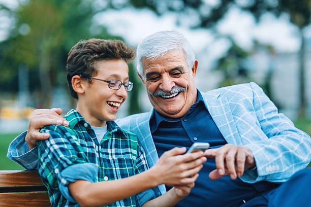 istock Senior man and little boy with smart phone 528314883