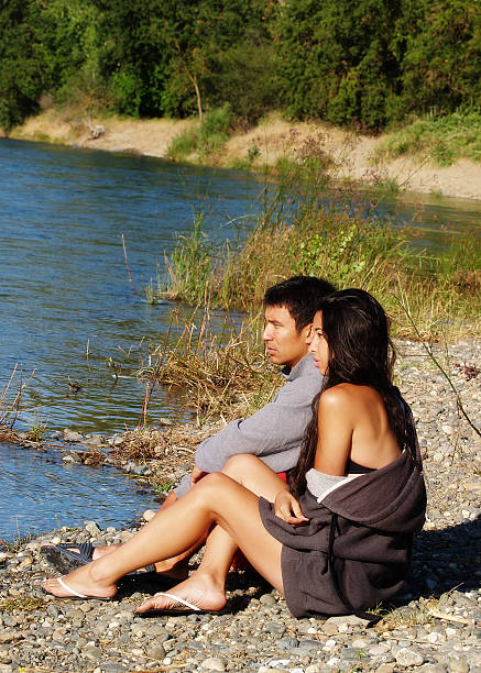 istock Ethnic Couple Sitting Outdoors On River Bank 528317629