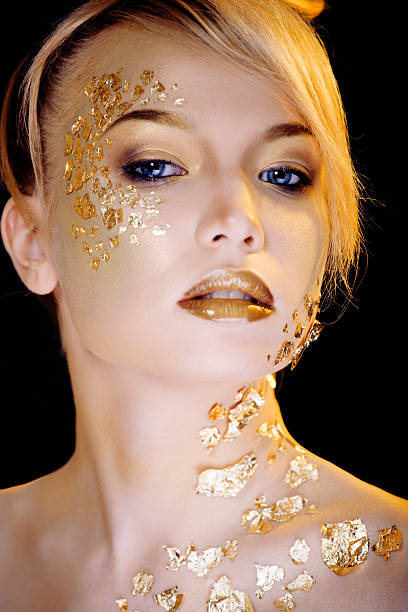 istock beauty blond woman with gold creative make up 528317793