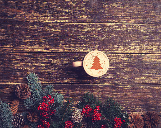 istock Cup of coffee with cream christmas tree on a table. 528336715