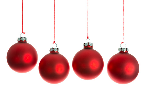 Red Christmas balls hanging at a rope over white