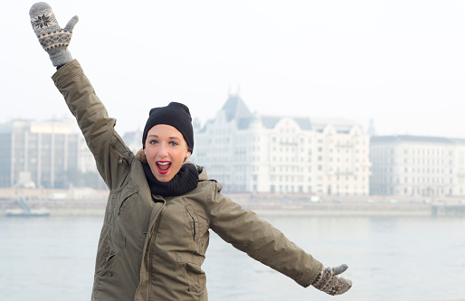 Young woman happy with extended arms and smiling .Winter season in Budapest city Hungary Europe.