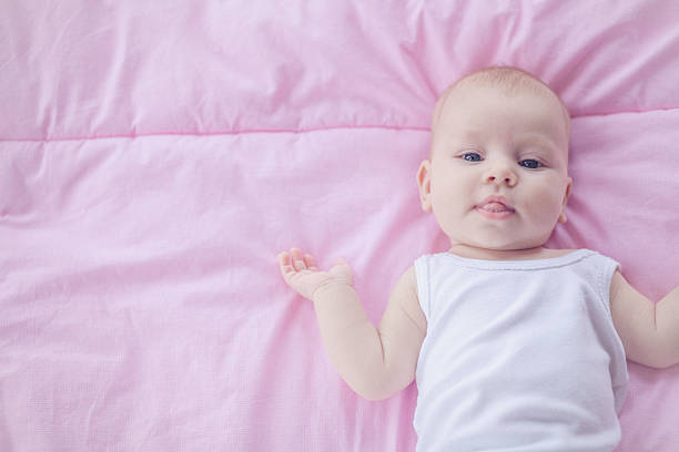 istock Cute baby girl lying at her back gesturing 528341839