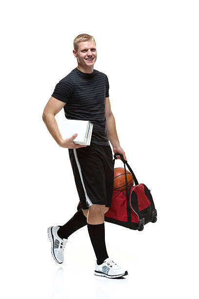istock Smiling male student holding books & walking 528343953
