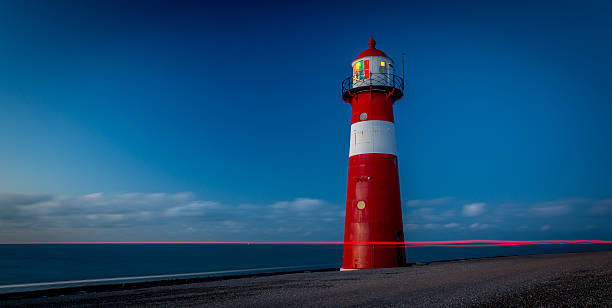 istock Red lighthouse on the dike in the Netherlands 528357629