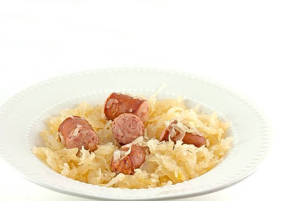 Baked sauerkraut and kielbasa plated on a white background.