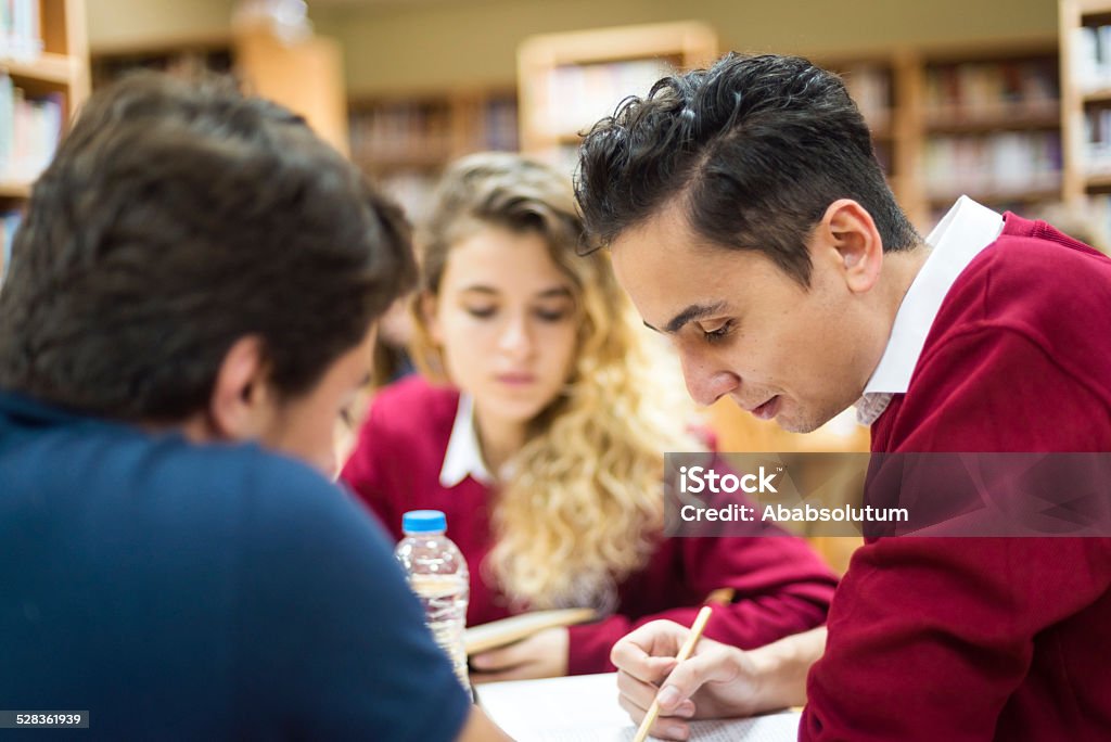 three Turkish students studying at library Turkish students, two male and one female, studing at the library, secondary school, university,  Istanbul, Turkey. Nikon D800, full frame, XXXL. Selective focus. Literature Stock Photo