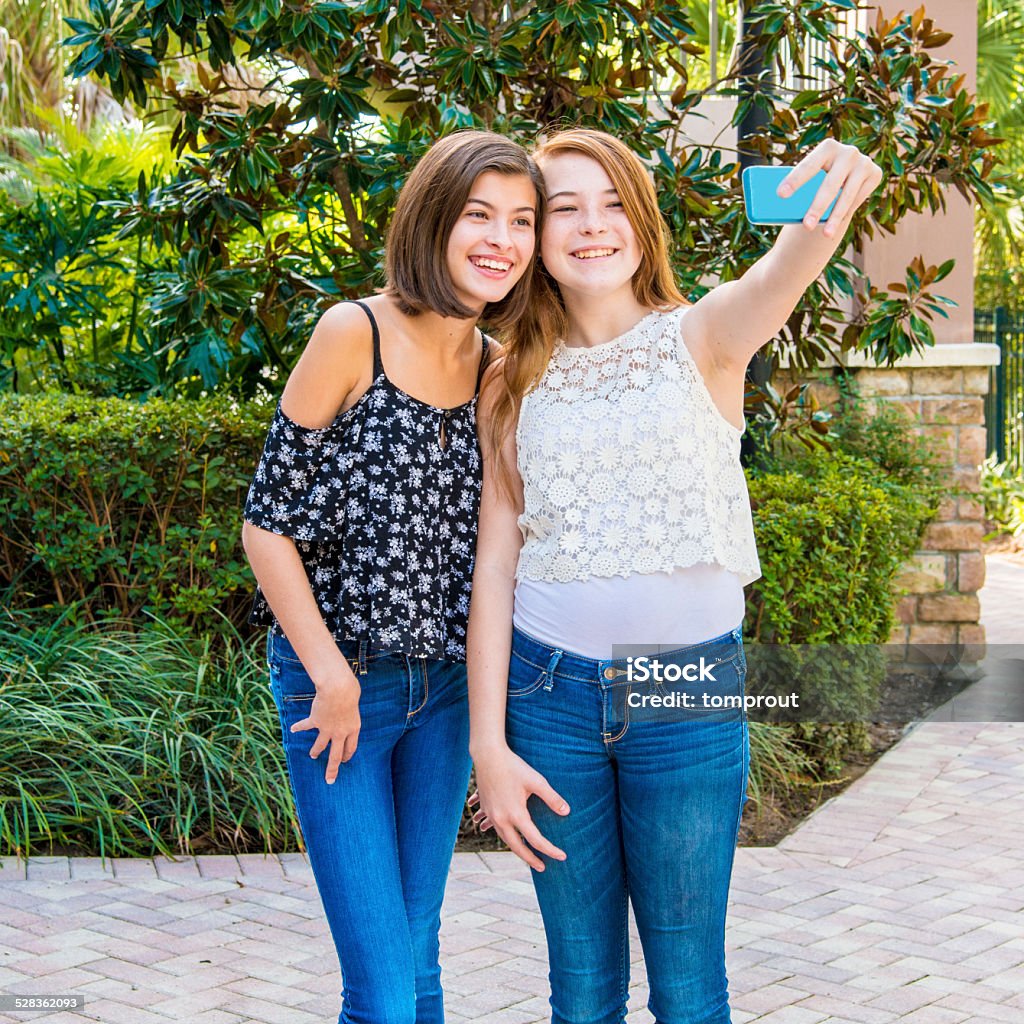 Best Friends Taking Selfies Two thirteen year-old girls are best friends and are taking selfies with a smart phone. 14-15 Years Stock Photo