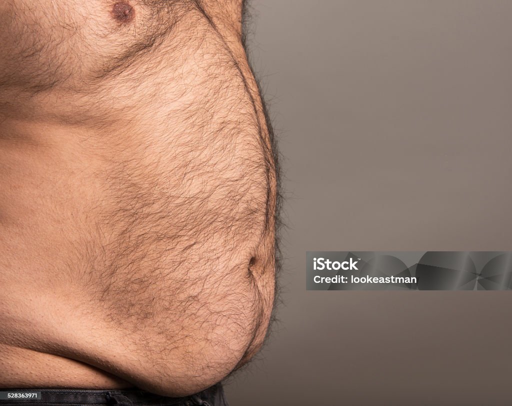 Image of overweight mans stomach Studio image of overweight mans stomach and chest. With copy space, ready to add your text. Navy Stock Photo